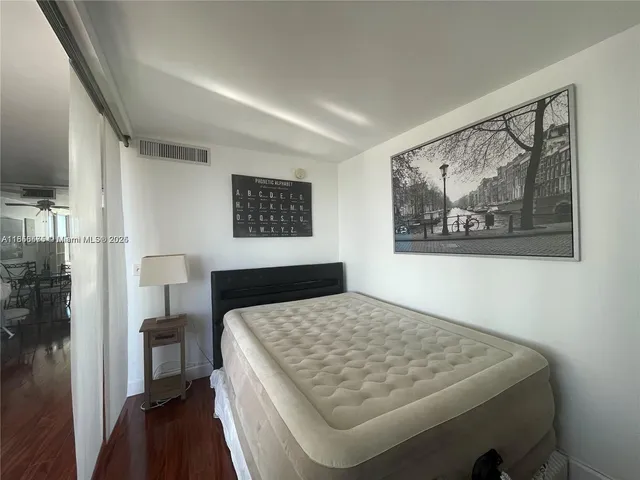 a bedroom with a bed and a painting on the wall