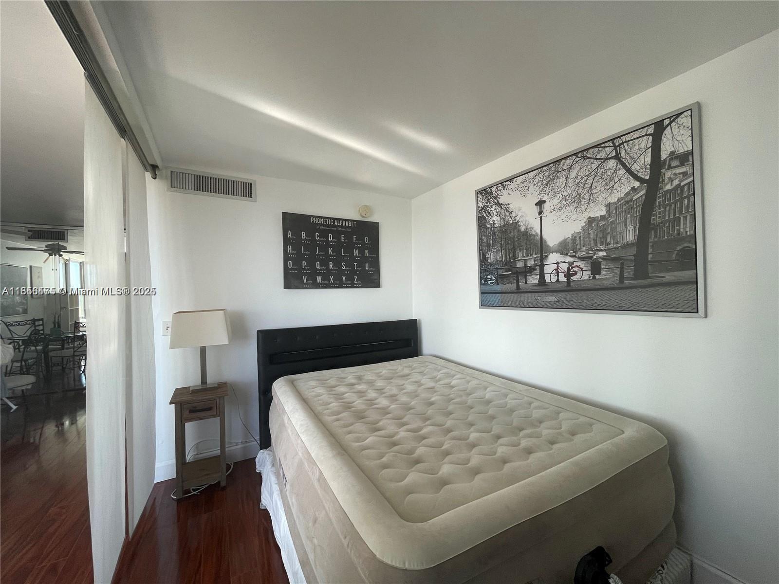 2899 Collins Avenue, Unit 1420 Miami Beach, FL 33140 - Photo 15 of 17 a bedroom with a bed and a painting on the wall