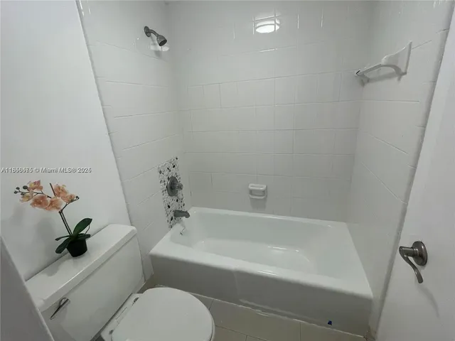 a white bath tub sitting next to a white toilet and sink
