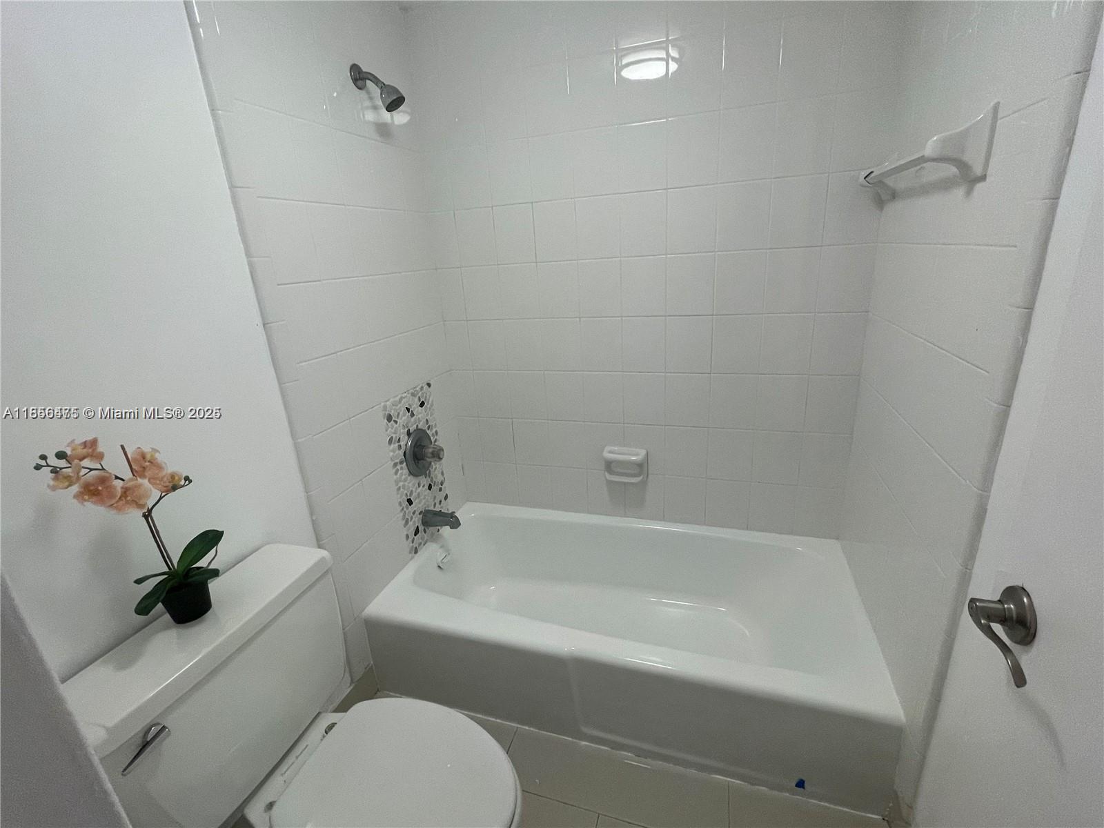 2899 Collins Avenue, Unit 1420 Miami Beach, FL 33140 - Photo 9 of 17 a white bath tub sitting next to a white toilet and sink