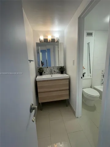 a bathroom with a sink mirror and toilet