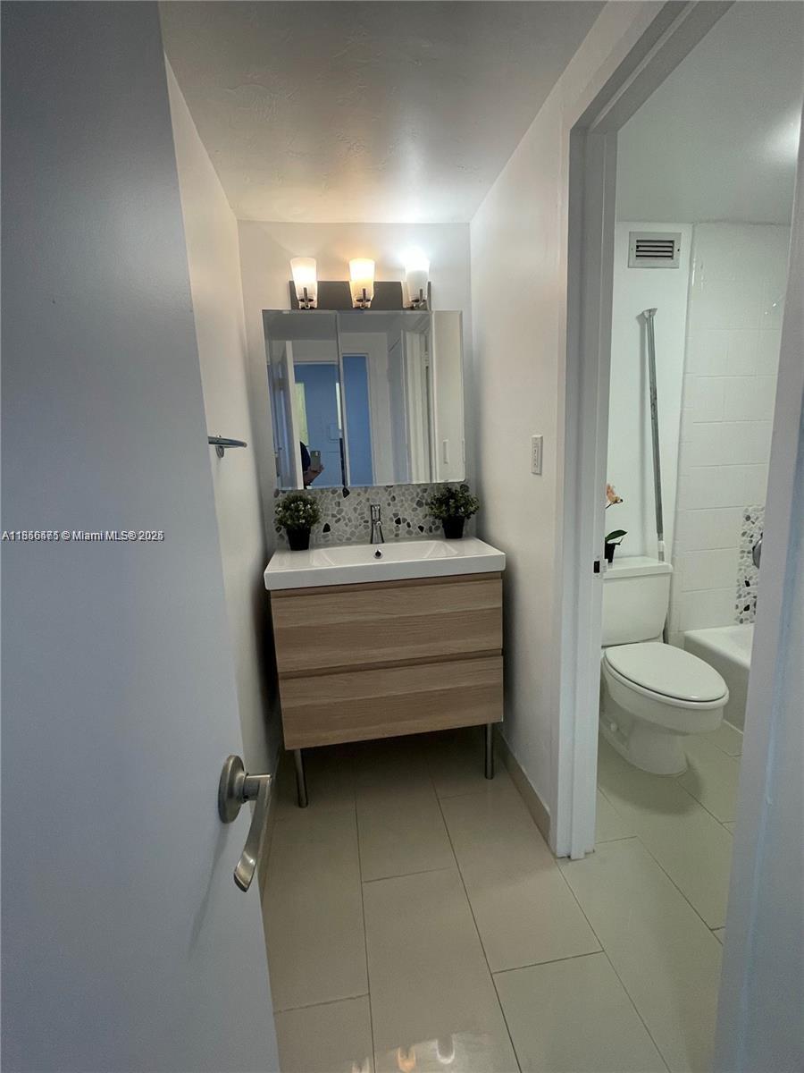 2899 Collins Avenue, Unit 1420 Miami Beach, FL 33140 - Photo 10 of 17 a bathroom with a sink mirror and toilet