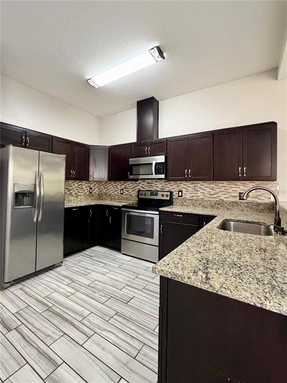 4848 Tampa Downs Boulevard Lutz, FL 33559 - Photo 2 of 27 a kitchen with a sink a microwave a refrigerator and cabinets