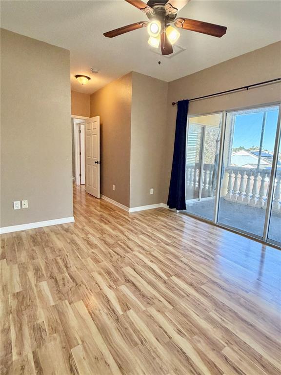 4848 Tampa Downs Boulevard Lutz, FL 33559 - Photo 6 of 27 an empty room with wooden floor and windows