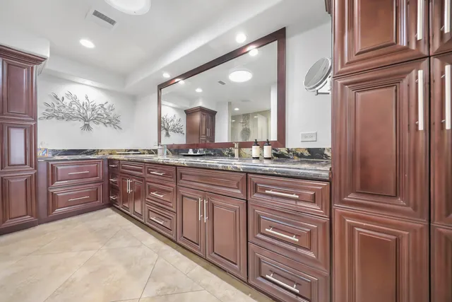 a spacious bathroom with a granite countertop sink and a mirror