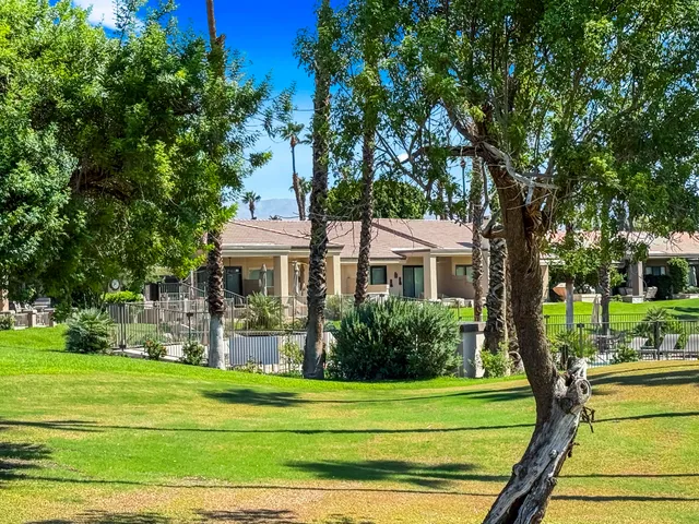 a front view of a house with a garden and trees