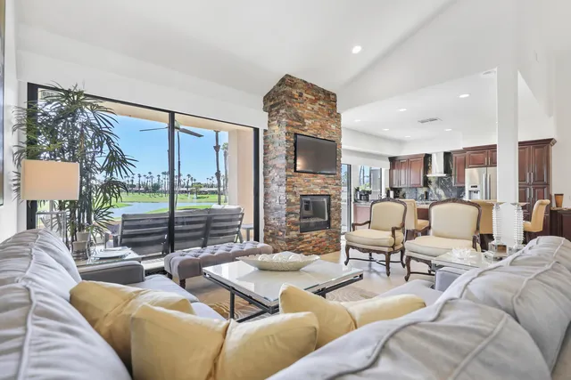 a living room with furniture wooden floor and a floor to ceiling window