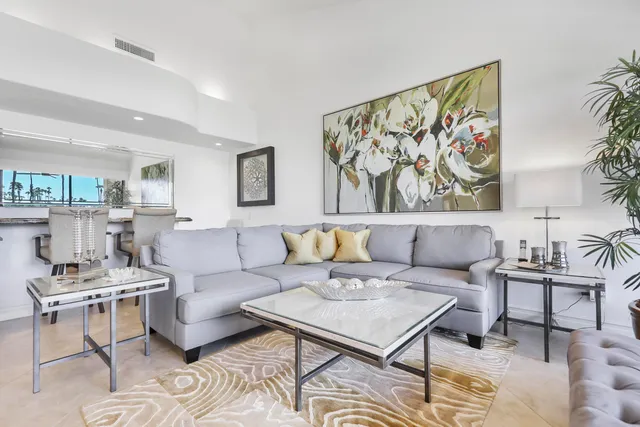 a living room with furniture a rug and a painting on the wall