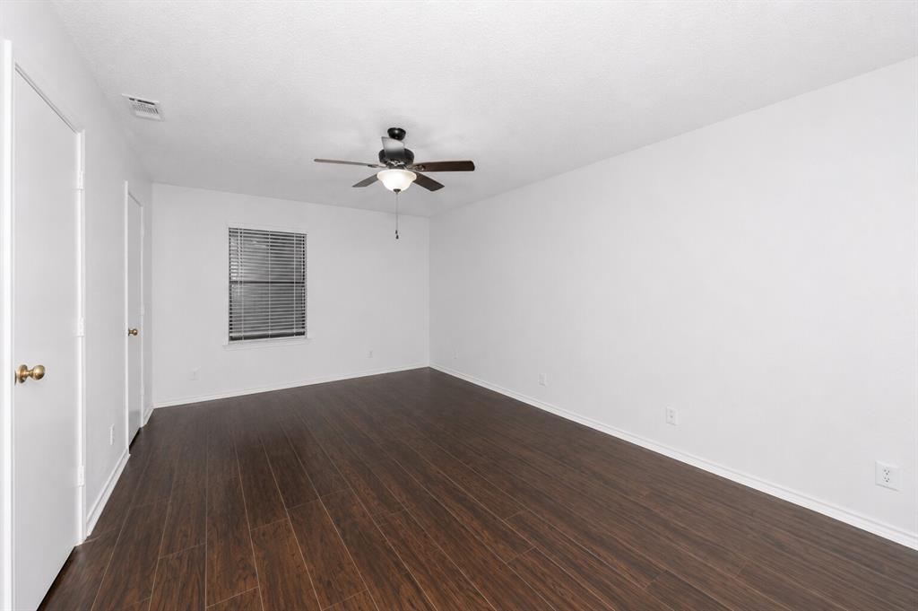 1001 Rosebud Drive Azle, TX 76020 - Photo 20 of 36 Spacious room featuring dark wood-finish flooring, a ceiling fan with light fixture, white walls, and a window with blinds