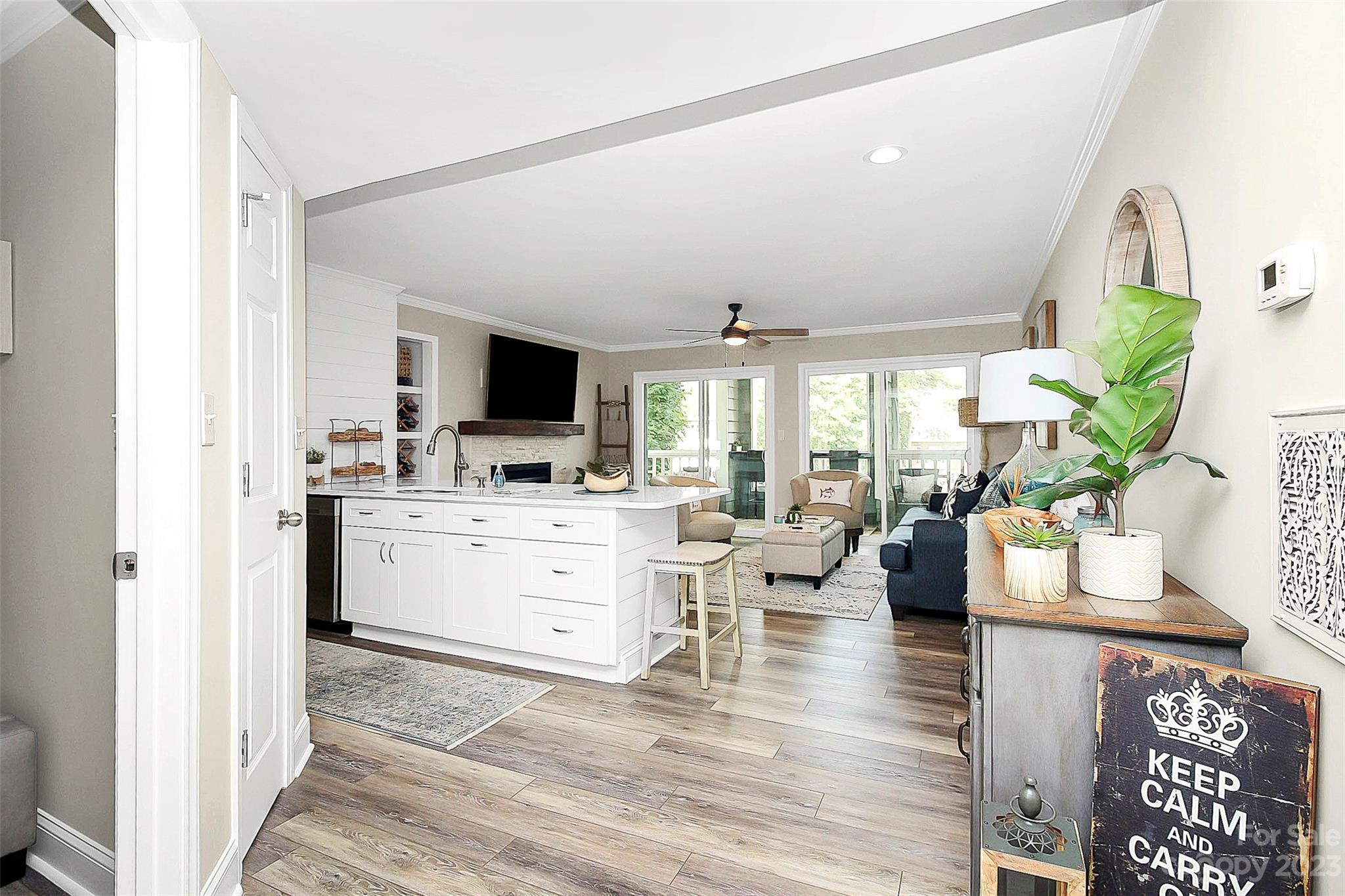 205 Northwest Drive, Unit 38 Davidson, NC 28036 - Photo 4 of 32 a room with lots of white furniture a flat screen tv and a floor to ceiling window