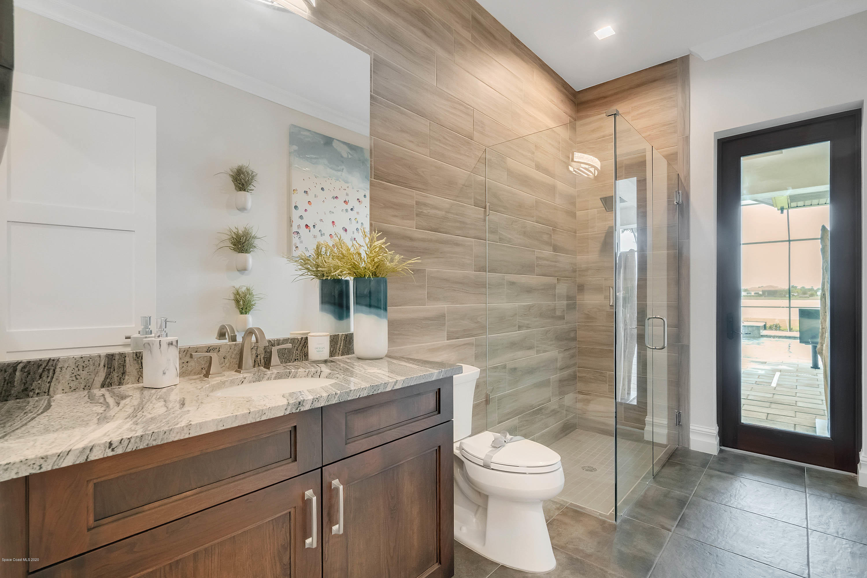 4533 Milost Drive Rockledge, FL 32955 - Photo 29 of 49 a bathroom with a granite countertop toilet a sink and a mirror