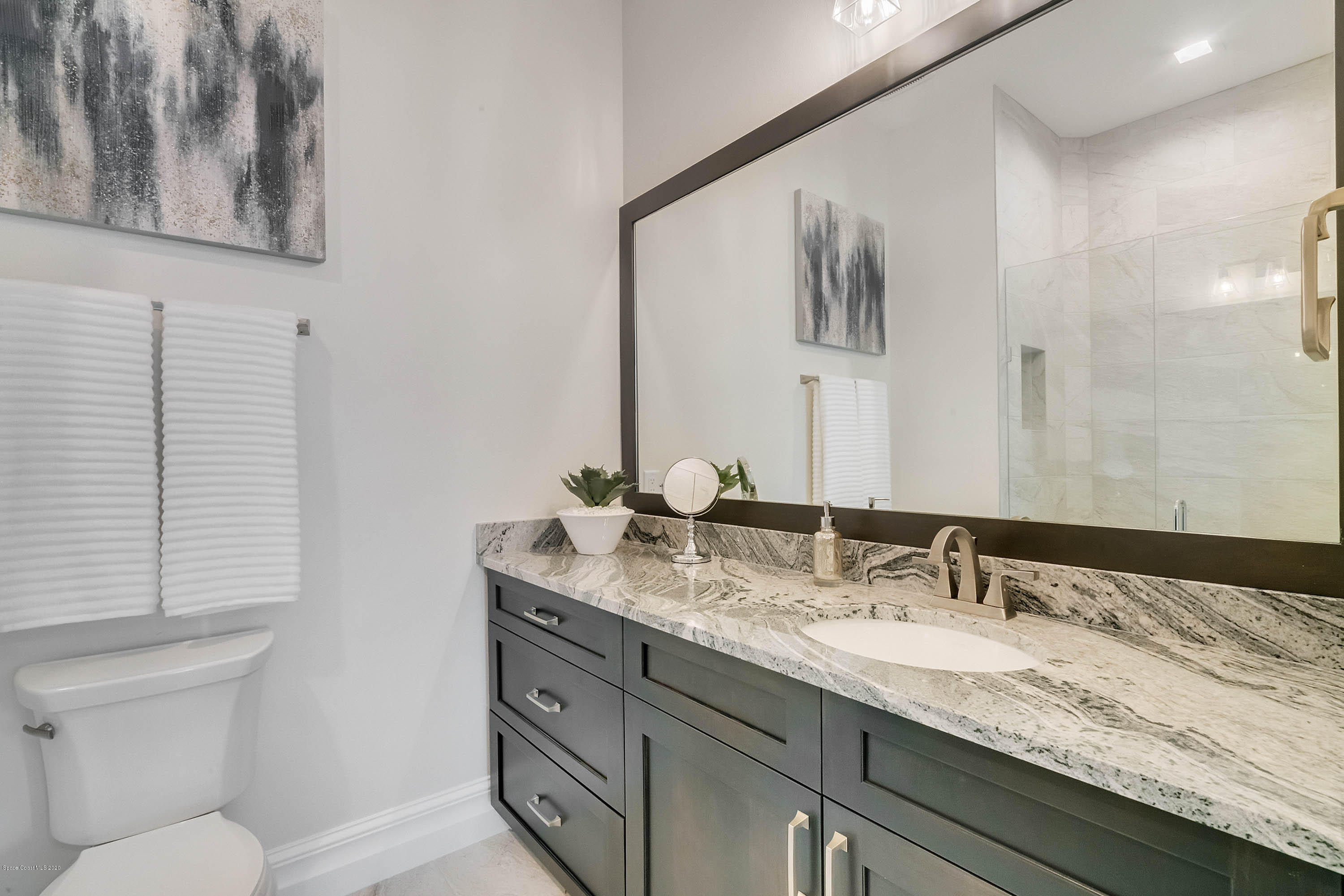 4533 Milost Drive Rockledge, FL 32955 - Photo 38 of 49 a bathroom with a granite countertop sink and a toilet