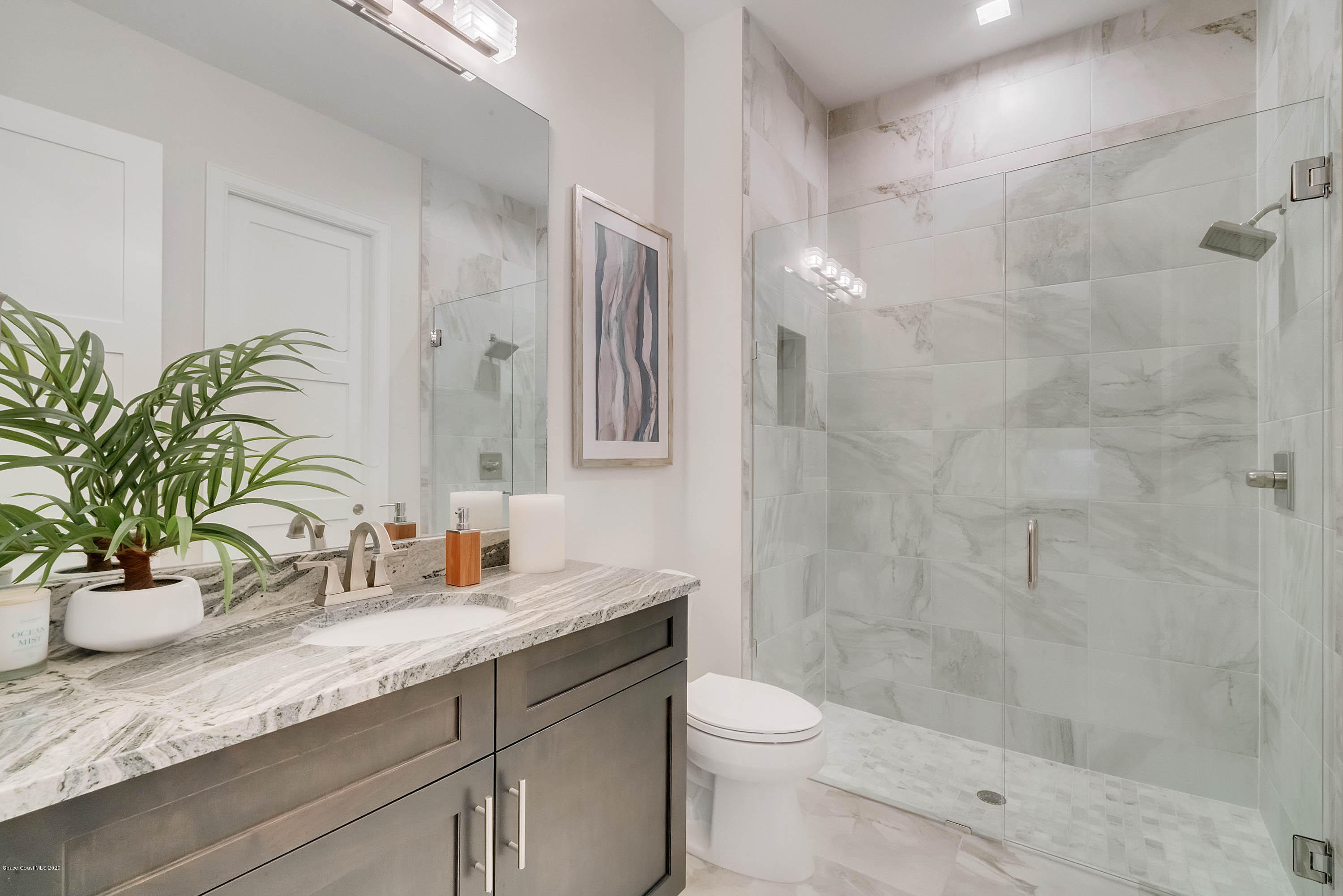 4533 Milost Drive Rockledge, FL 32955 - Photo 39 of 49 a bathroom with a granite countertop sink a toilet and shower