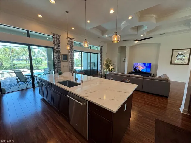 a kitchen with stainless steel appliances granite countertop wooden floor sink stove and wooden cabinets