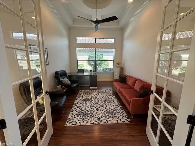 a living room with furniture a flat screen tv and a large window