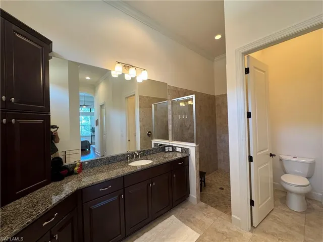 a spacious bathroom with a granite countertop sink mirror and toilet