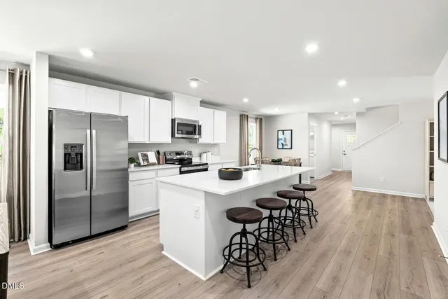 a kitchen with a dining table chairs and white appliances
