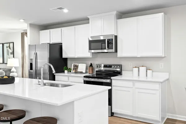 a kitchen with granite countertop a sink a counter top space stainless steel appliances and cabinets