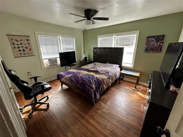 a bedroom with a bed and wooden floor