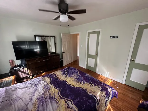 a bedroom with a bed and wooden floor