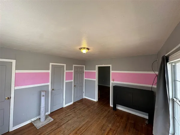 a view of a room with wooden floor and a window