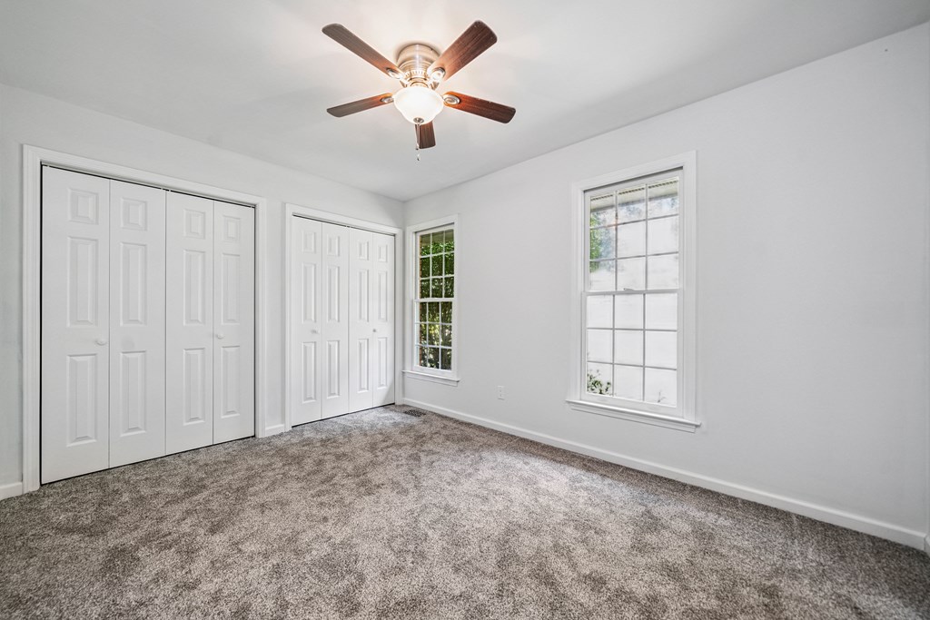 5055 Wright Bridge Road Cumming, GA 30028 - Photo 19 of 39 an empty room with chandelier fan and windows