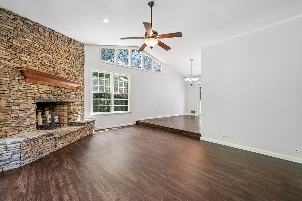 5055 Wright Bridge Road Cumming, GA 30028 - Photo 7 of 39 an empty room with wooden floor fireplace and windows