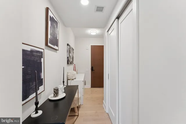 a view of a hallway with couches and wooden floor