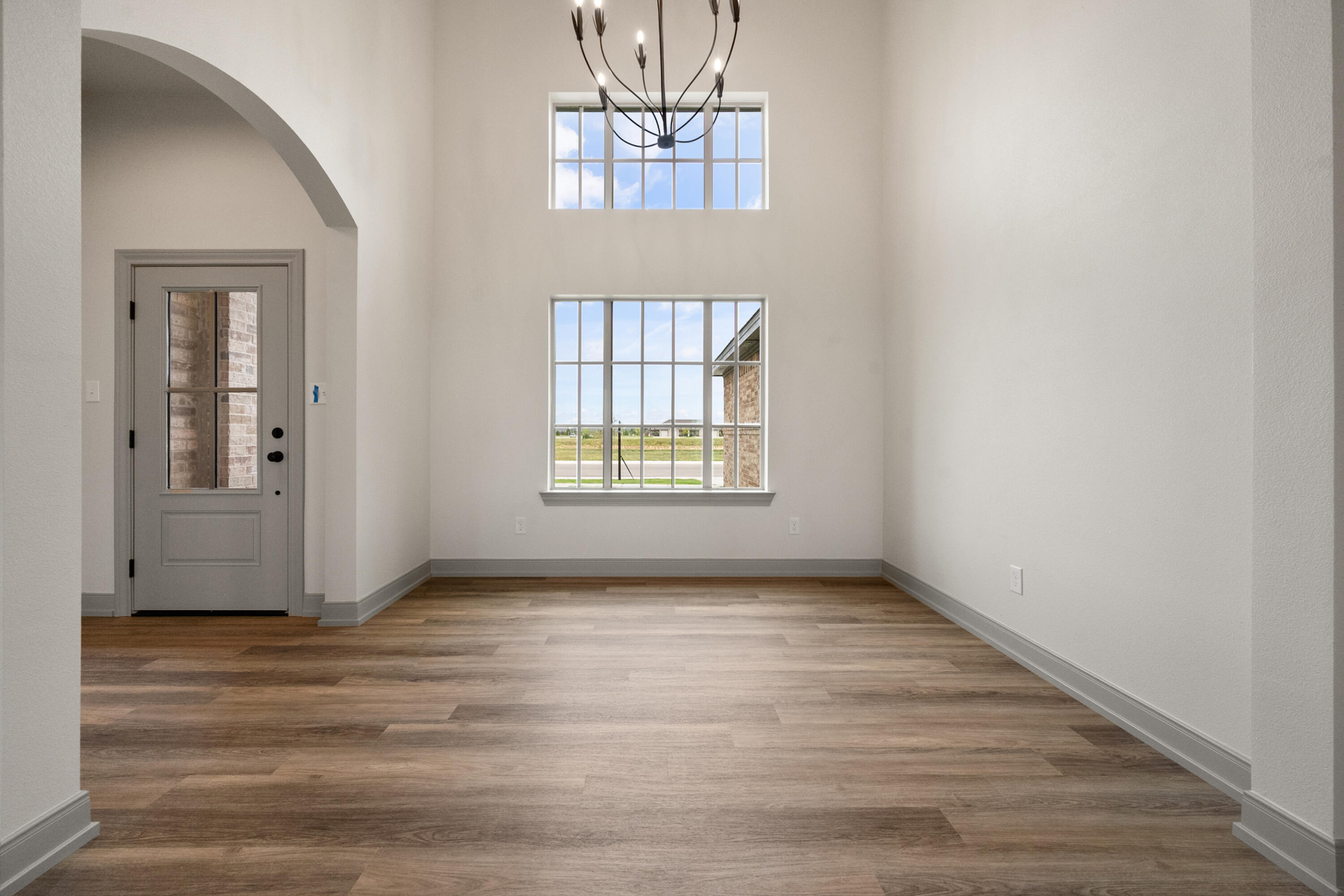 1005 North 5th Street Wolfforth, TX 79382 - Photo 7 of 36 an empty room with wooden floor a chandelier