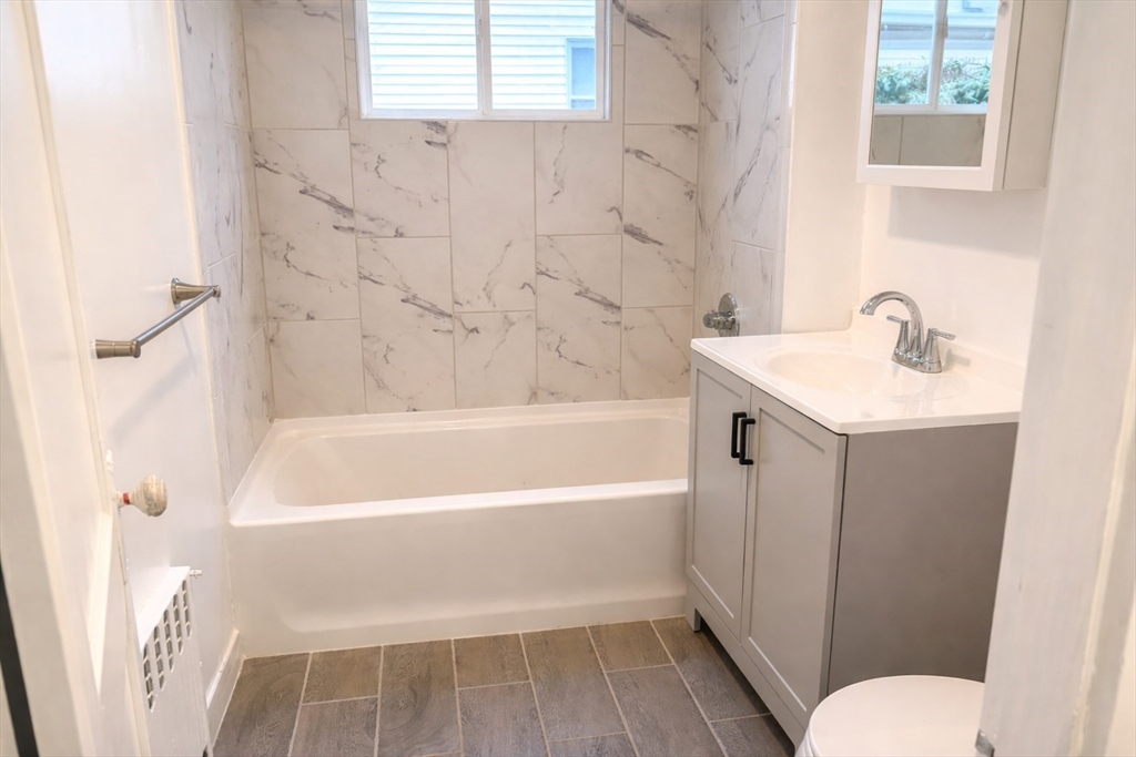 14 Walter Street, Unit 1 Boston, MA 02131 - Photo 8 of 14 a bathroom with a sink a toilet and a bathtub