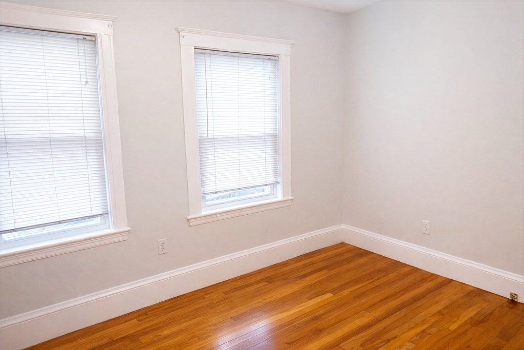 14 Walter Street, Unit 1 Boston, MA 02131 - Photo 10 of 14 an empty room with wooden floor and windows