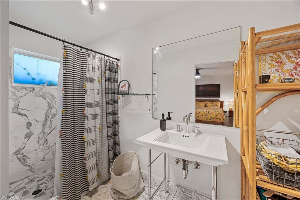 1304 Milano Drive Naples, FL 34103 - Photo 13 of 37 a bathroom with a sink a toilet and shower