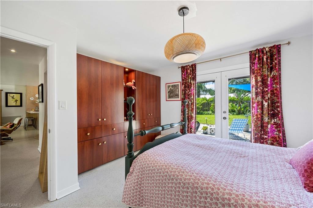 1304 Milano Drive Naples, FL 34103 - Photo 15 of 37 a bed room with a bed and a chandelier