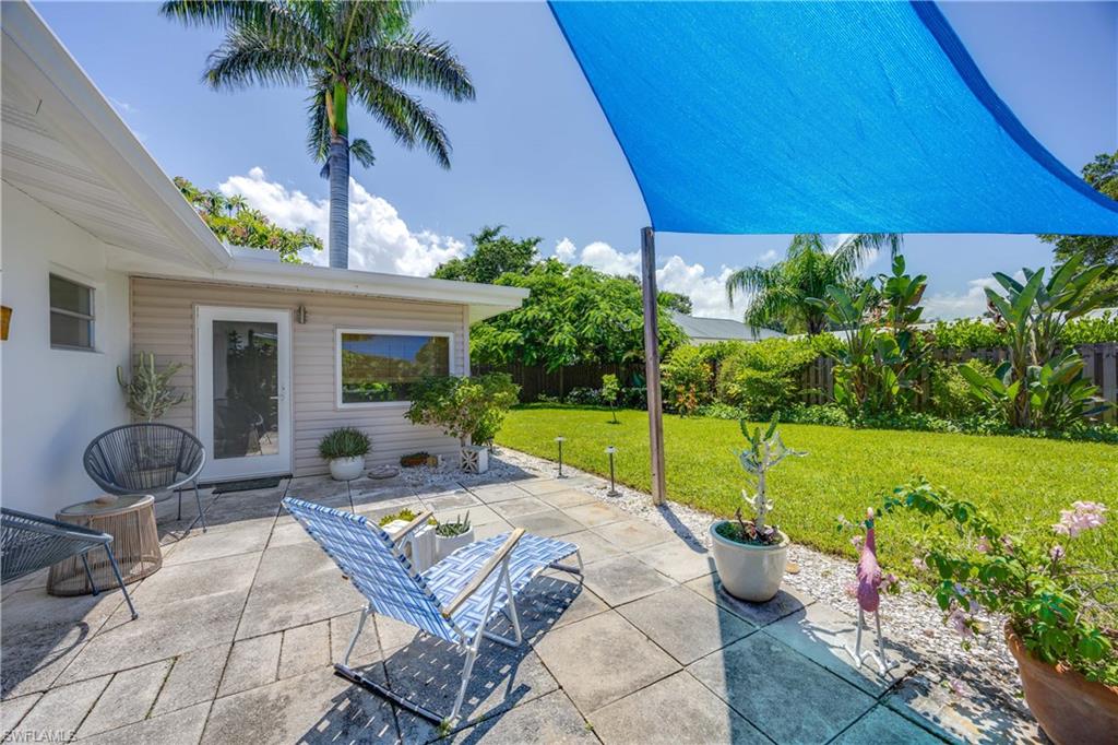 1304 Milano Drive Naples, FL 34103 - Photo 25 of 37 a view of a backyard with table and chair under an umbrella