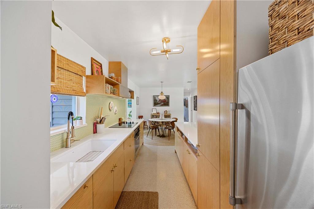 1304 Milano Drive Naples, FL 34103 - Photo 5 of 37 a kitchen with stainless steel appliances a refrigerator and a stove
