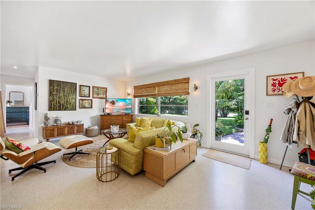 1304 Milano Drive Naples, FL 34103 - Photo 8 of 37 a living room with furniture flat screen tv and a large window