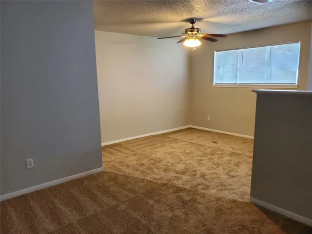 an empty room with a chandelier fan