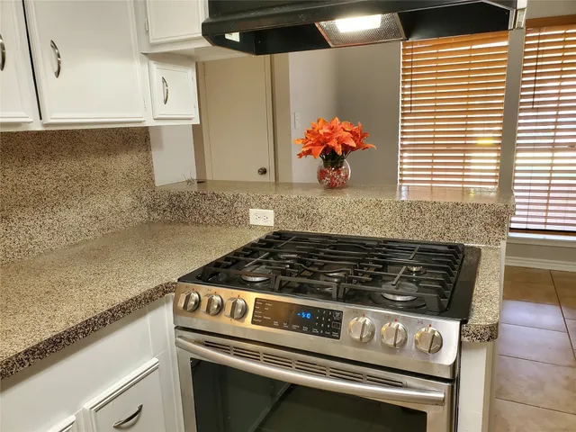 a stove top oven sitting inside of a kitchen