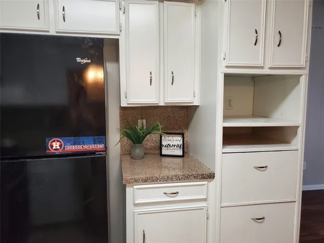 a kitchen with granite countertop white cabinets and white appliances