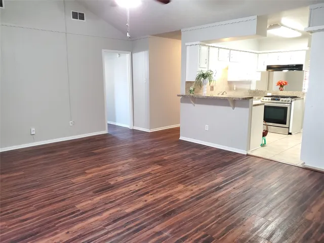 a kitchen with granite countertop wooden floors and white walls