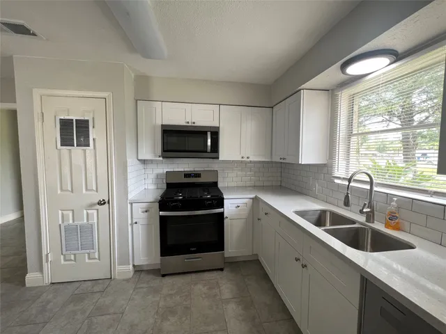 a kitchen with a sink appliances and cabinets