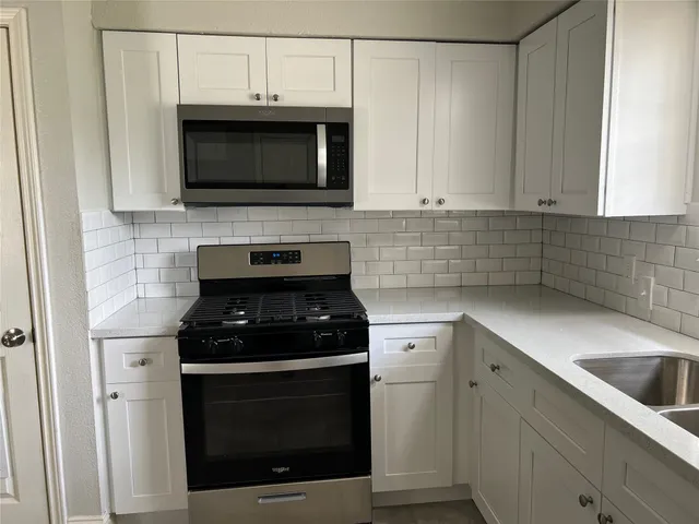 a kitchen with stainless steel appliances a stove a microwave and sink