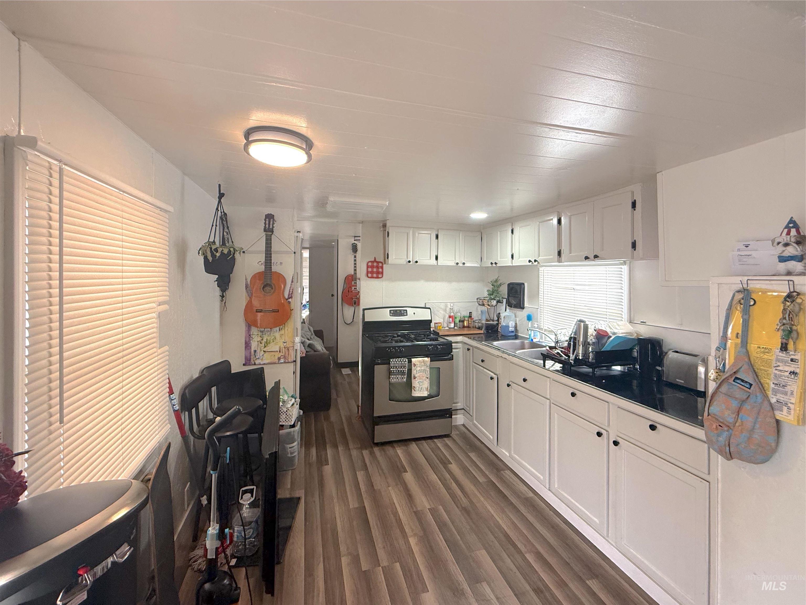 6728 West Fairview Avenue, Unit 24 Boise, ID 83704 - Photo 6 of 9 Kitchen featuring white cabinets, stainless steel gas range oven, and dark wood-type flooring
