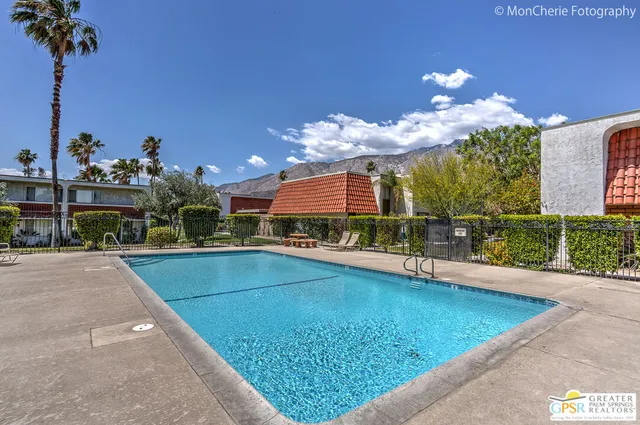 a view of a swimming pool with a table and chairs in front of it