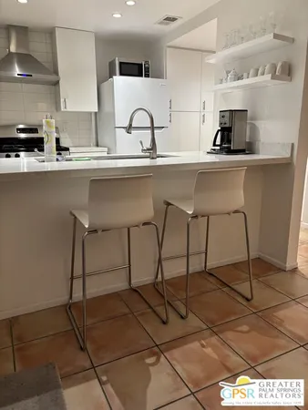 a kitchen with a sink and chairs