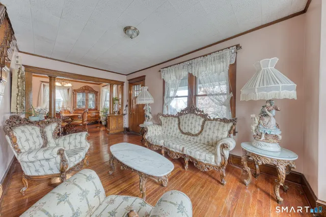 a dining room with furniture a chandelier and wooden floor
