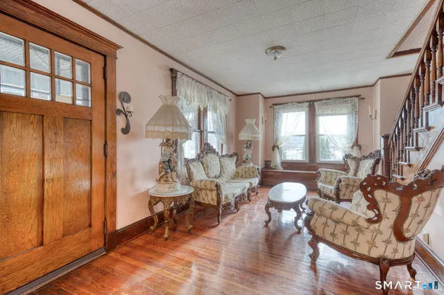 a living room with couches and a dining table with wooden floor