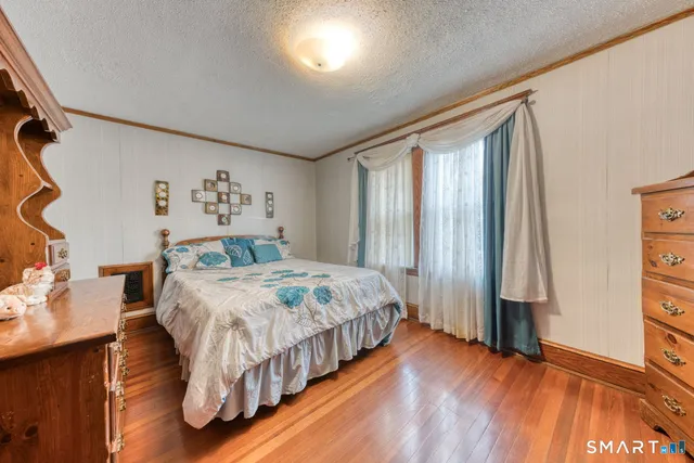 a bedroom with a bed and a dresser next to a window