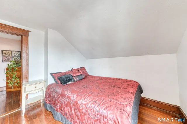 a bedroom with a bed and wooden floor