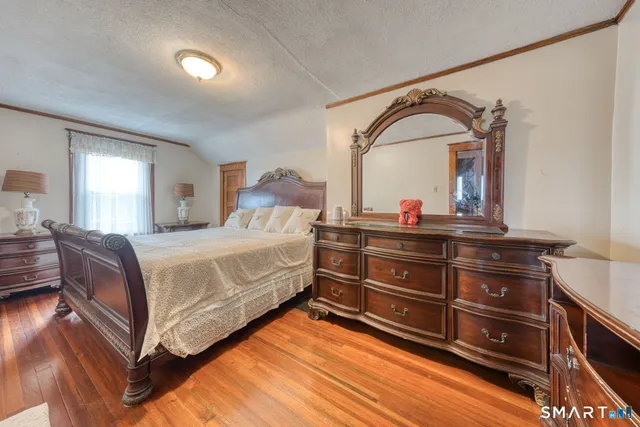 a bedroom with a bed and a dresser with mirror